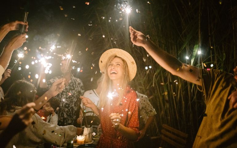 Photo of a young woman celebrating and having a summer dinner party with her family and friends.