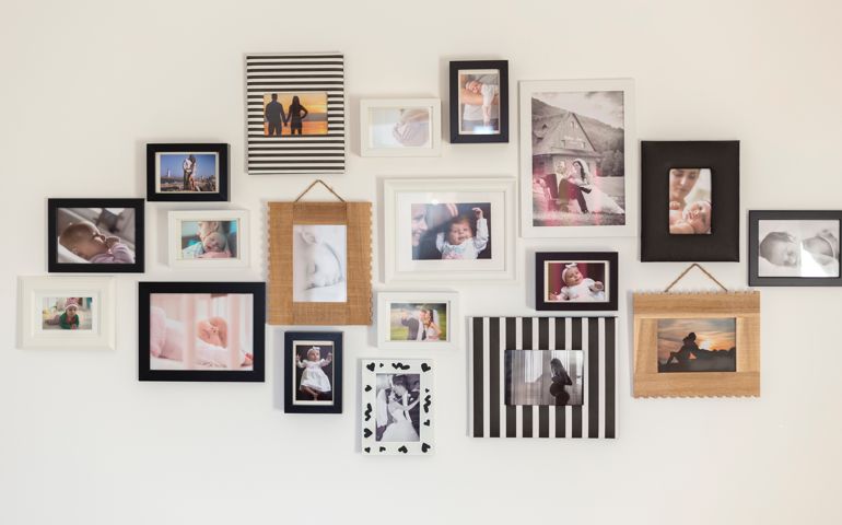 white wall with photos of the family in various photo frames