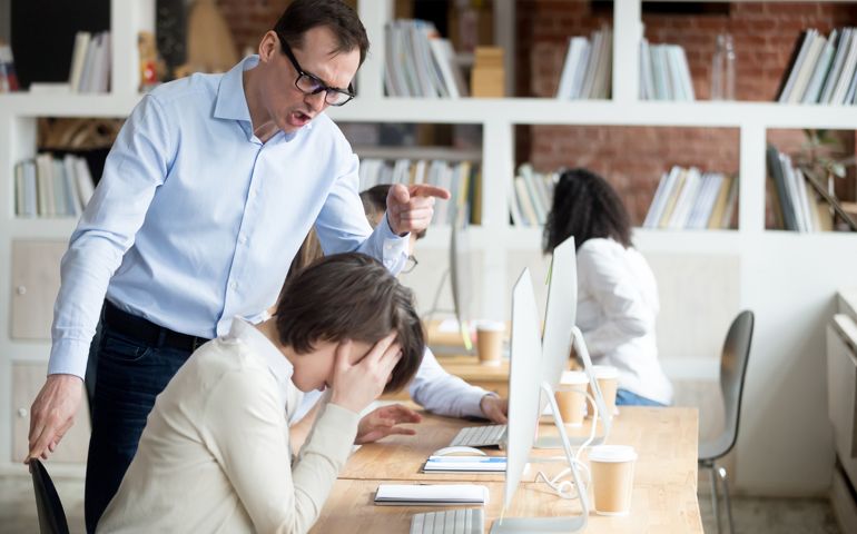 Furious businessman shout at female employee working in shared office, mad male boss scream