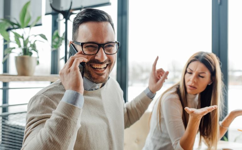 Frustrated angry woman waiting for him to finish phone call.