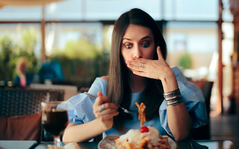 Person experiencing overeating side effects at lunch