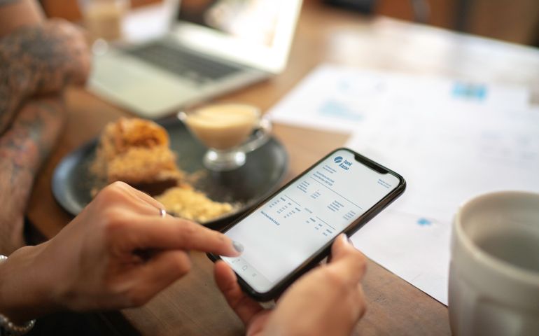 Woman checking account statement of her digital investment on her mobile phone