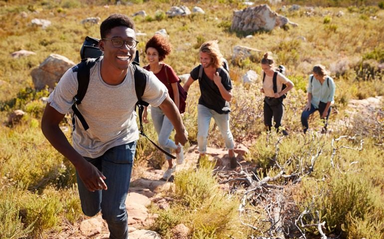 group of friends hiking up a hillside