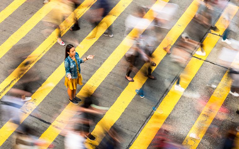 A woman has a moment of peace and calm on a crowded crosswalk