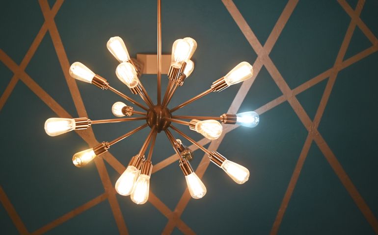 Modern chandelier with one white bulb.