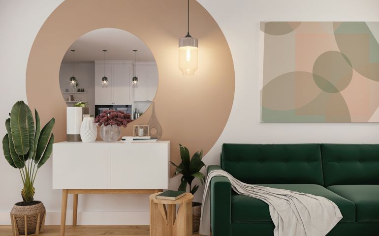 Picture of a cozy, green sofa in the colorful living room with geometric decoration