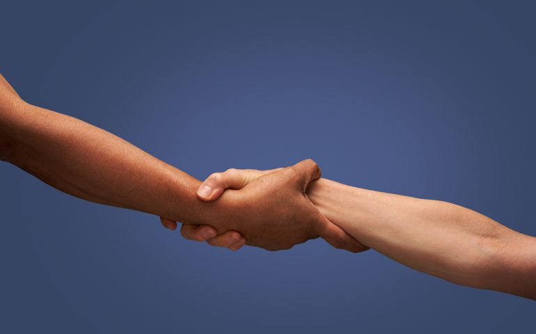 Close up of man and woman holding hands in studio with blue background