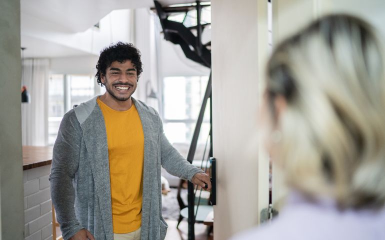 Man opening door to guest at home