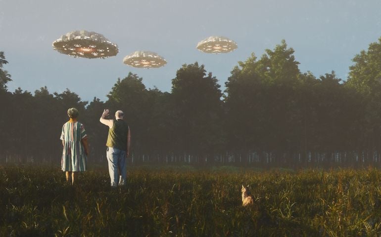Senior couple waving at flying UFOs