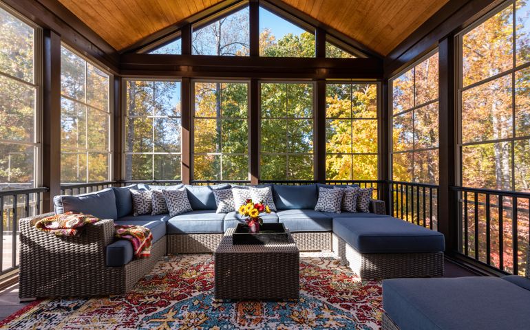 Cozy screened porch with contemporary furniture and flower bouquet in a vase,