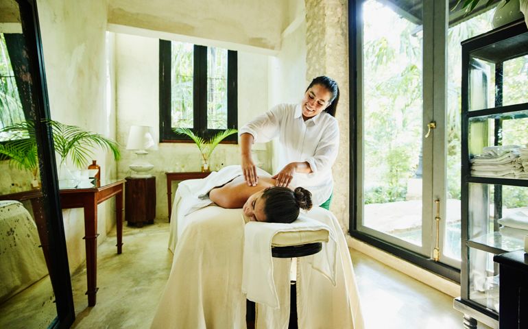 Wide shot of woman receiving massage at luxury spa