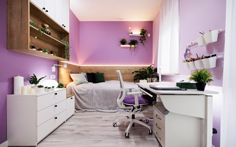 Modern luxury teenage girl's bedroom with desk and lot of plants. Bright wooden floor and lot of lamps.