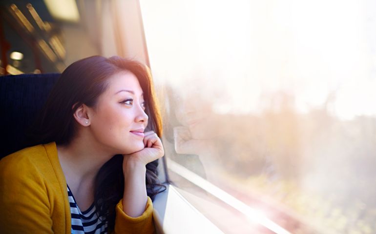Woman on a train day dreaming out the window.