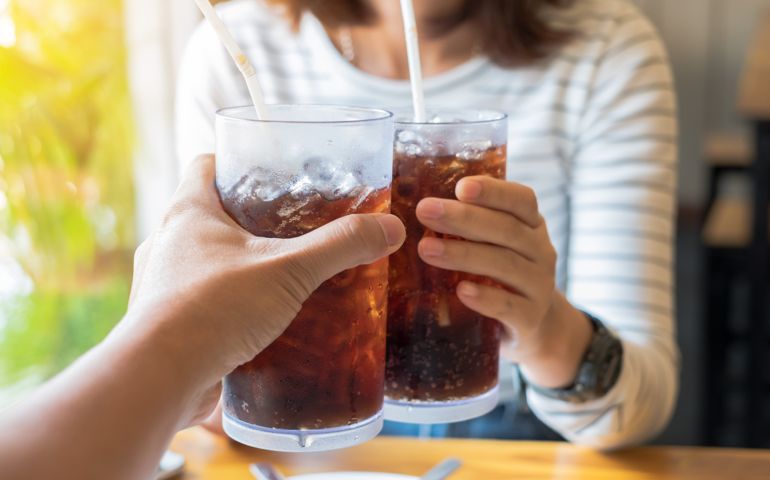 Men and Woman hand giving glass of cola.Glass of cola ,Soft drinks with ice, sweethart or buddy