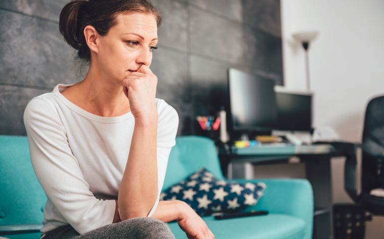 anxious woman sitting on a sofa in the living room