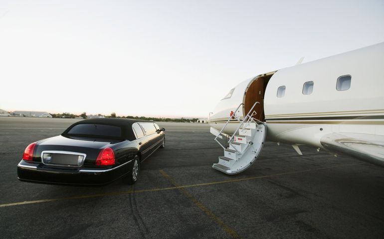 Stretch limo parked beside airplane