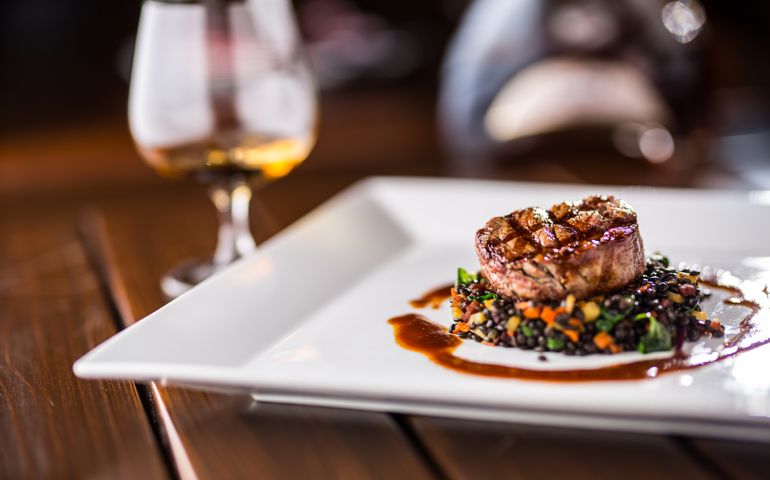 Beef Steak. Grill beef steak black lentils mixed with vegetable. Cognac or brandy as drink