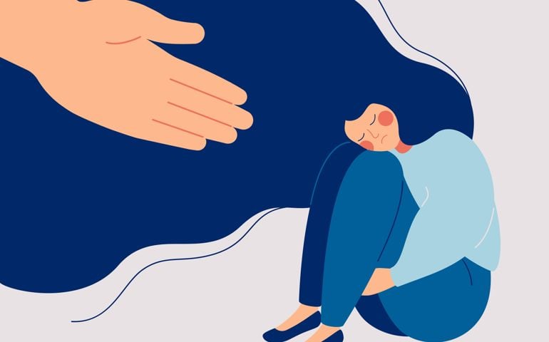 Human hand helps a sad lonely woman to get rid of depression. A young unhappy girl sits and hugs her knees. The concept of support and care for people under stress.