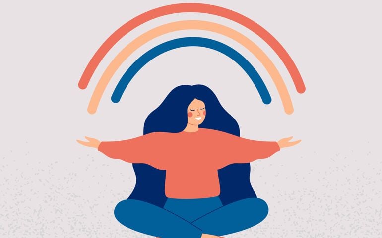 Happy woman sits in lotus pose and open her arms to the rainbow.