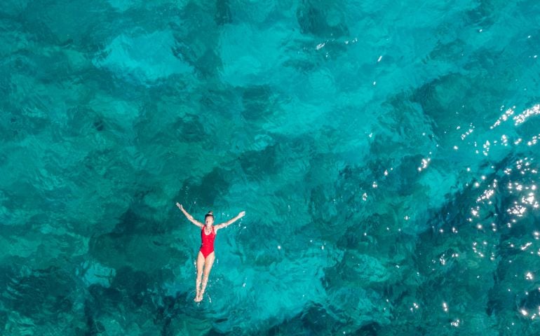 Woman floating turquoise sea