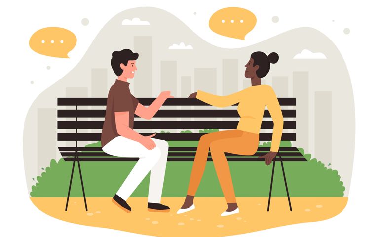 Romantic couple sitting on bench in city park and talking.