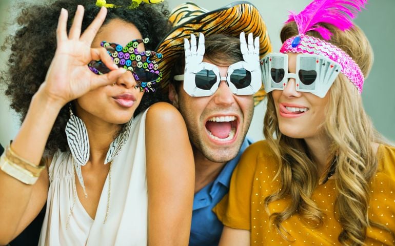 Smiling friends wearing decorative glasses