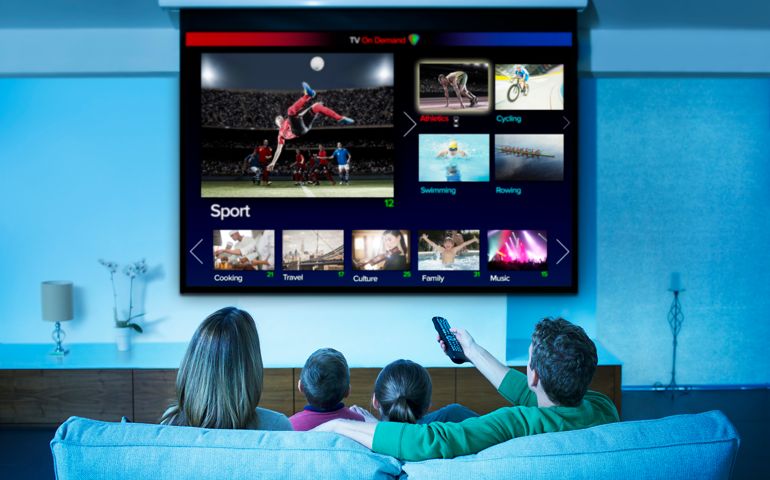 Family watching television in living room