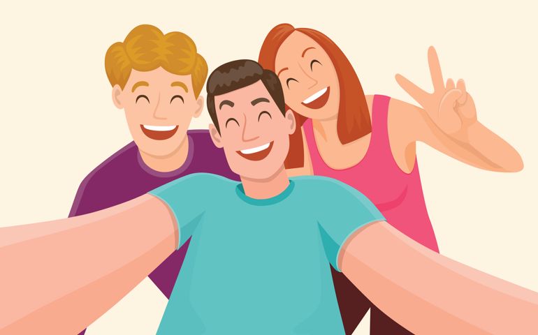 Group of three friends taking a selfie and laughing.