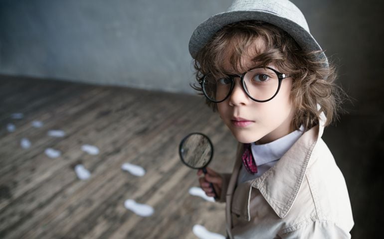 Little detective with a magnifying glass