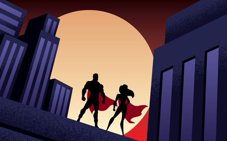 Superhero couple watching over the city from the roof of a tall building at night.