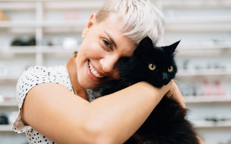 Woman hugs cat in bicycle shop