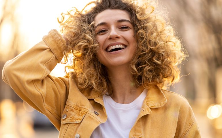 Portrait of young woman with curly hair in the city