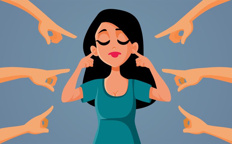 Girl covering her ears not listening to the critics pointing at her