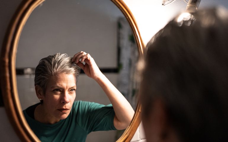 Mature woman getting ready at home