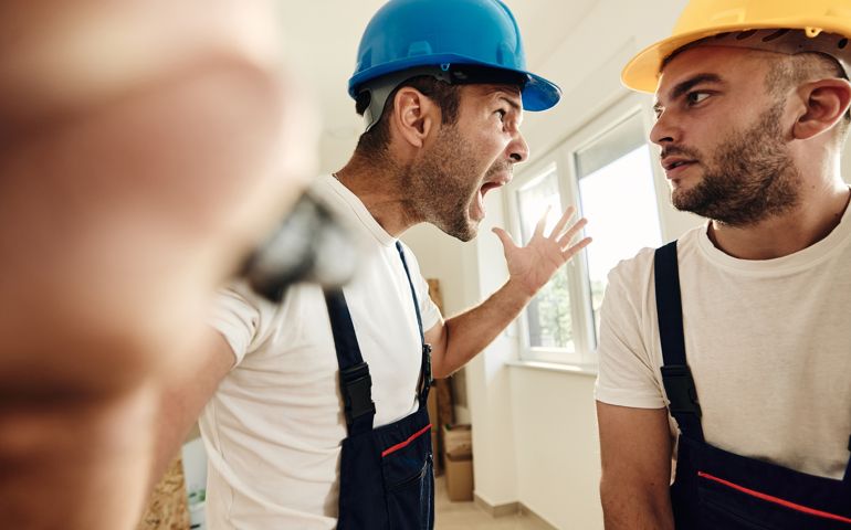Displeased worker screaming of anger at his colleague during home renovation process.
