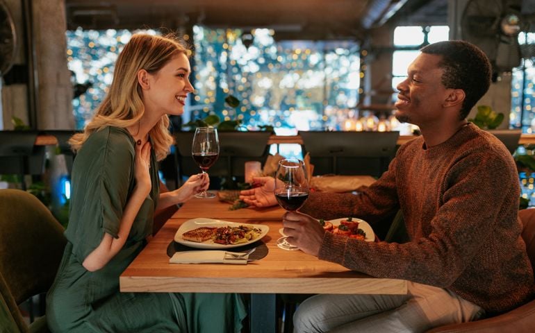 couple is on a date in a restaurant having dinner and wine on Valentines day.