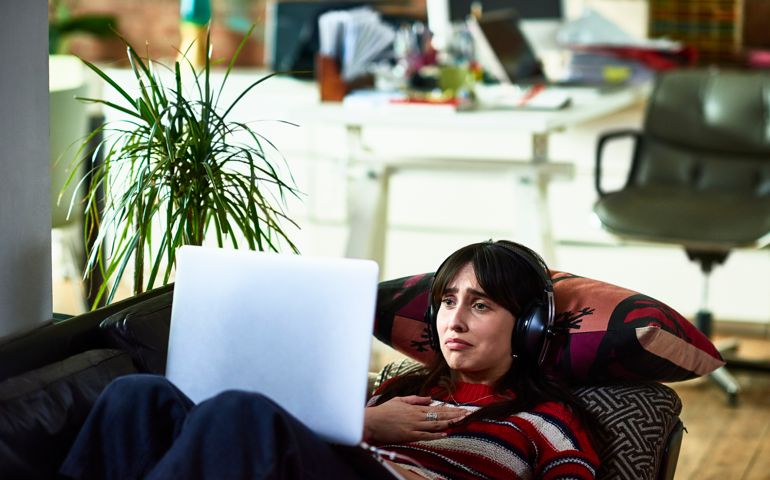 Emotional young woman using laptop and looking upset