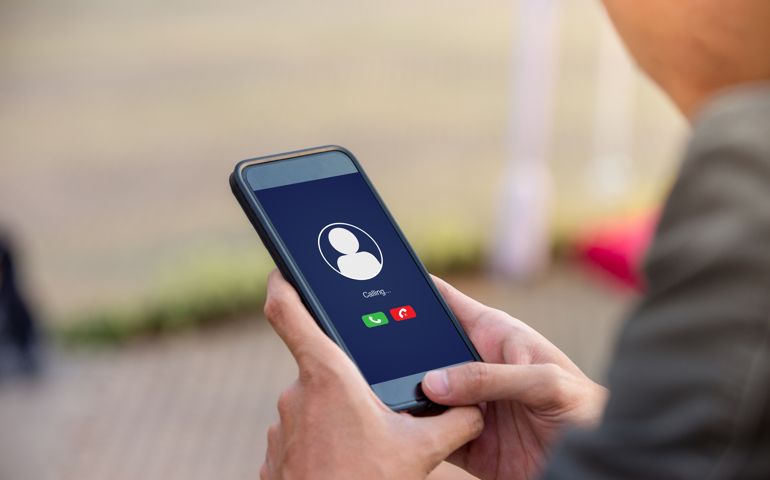 Voice call concept on the screen. Man holding smartphone doing voice call to someone.