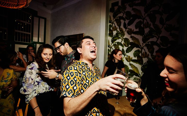 Laughing friends toasting during party in night club