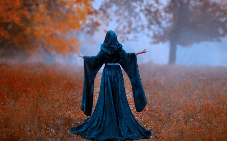 young priestess holds a secret rite of sacrifice, is alone in the autumn forest on a large glade.