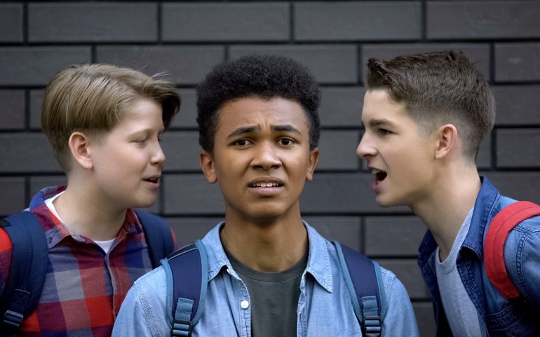 Cruel students teasing boy face-to-face