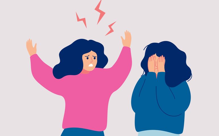 An angry woman screams at a crying woman who covers her face with her hands.