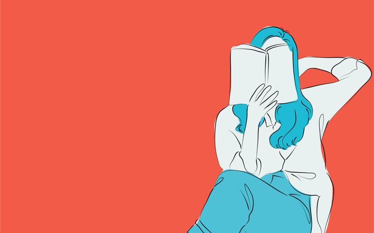 Close-up of female hands holding book on orange background, Girl reading book,