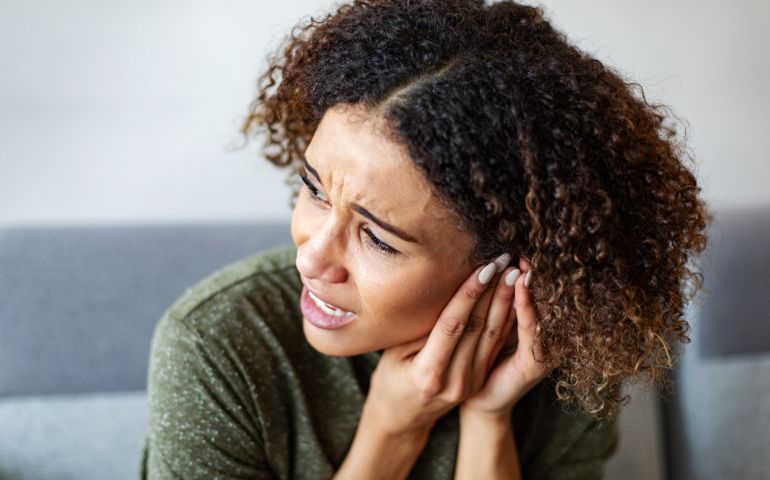 woman touching her ear in pain