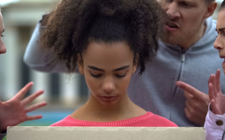 girl suffering people screaming racial insults, bullying problem