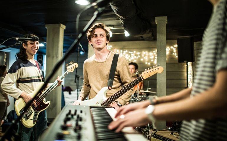 Young rock band rehearsing together and laughing