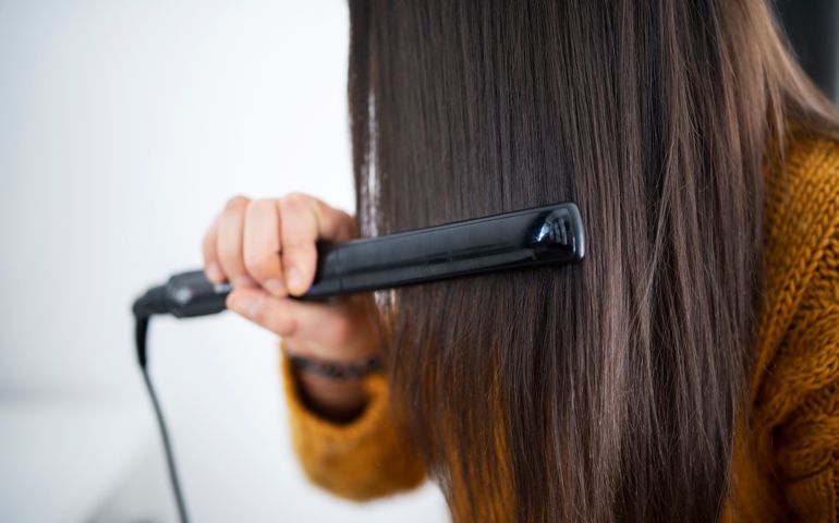 Woman using hair straightener