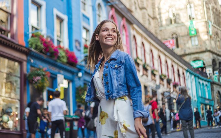Modern female tourist spending excited day visiting Victoria street in Edinburgh