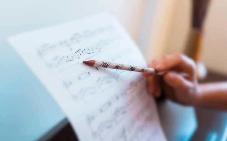 Unrecognizable woman teaching piano lessons at home