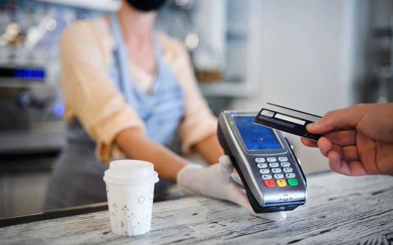 Contactless payment with debit card, coffee shop open after lockdown.